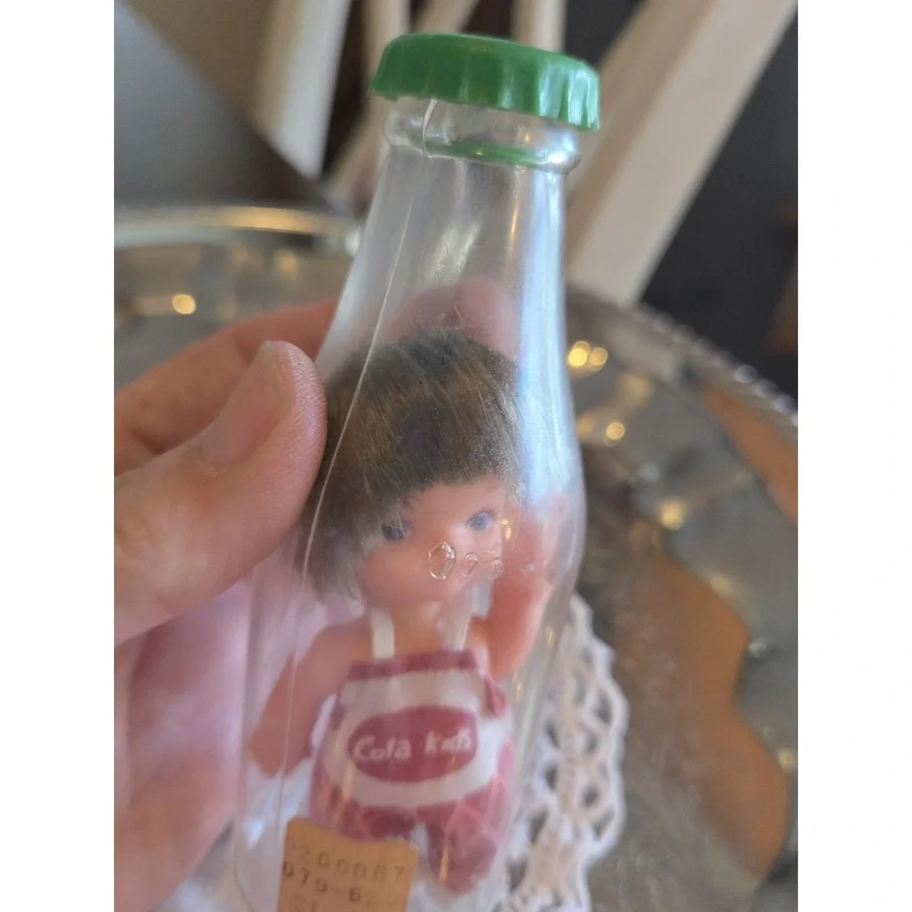 vintage 1960s Cola Kids doll is encased in a clear plastic bottle